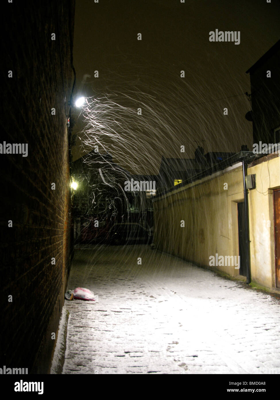 Falling snow being blown by the wind. Caught in a light, it makes trails and streaks. Stock Photo