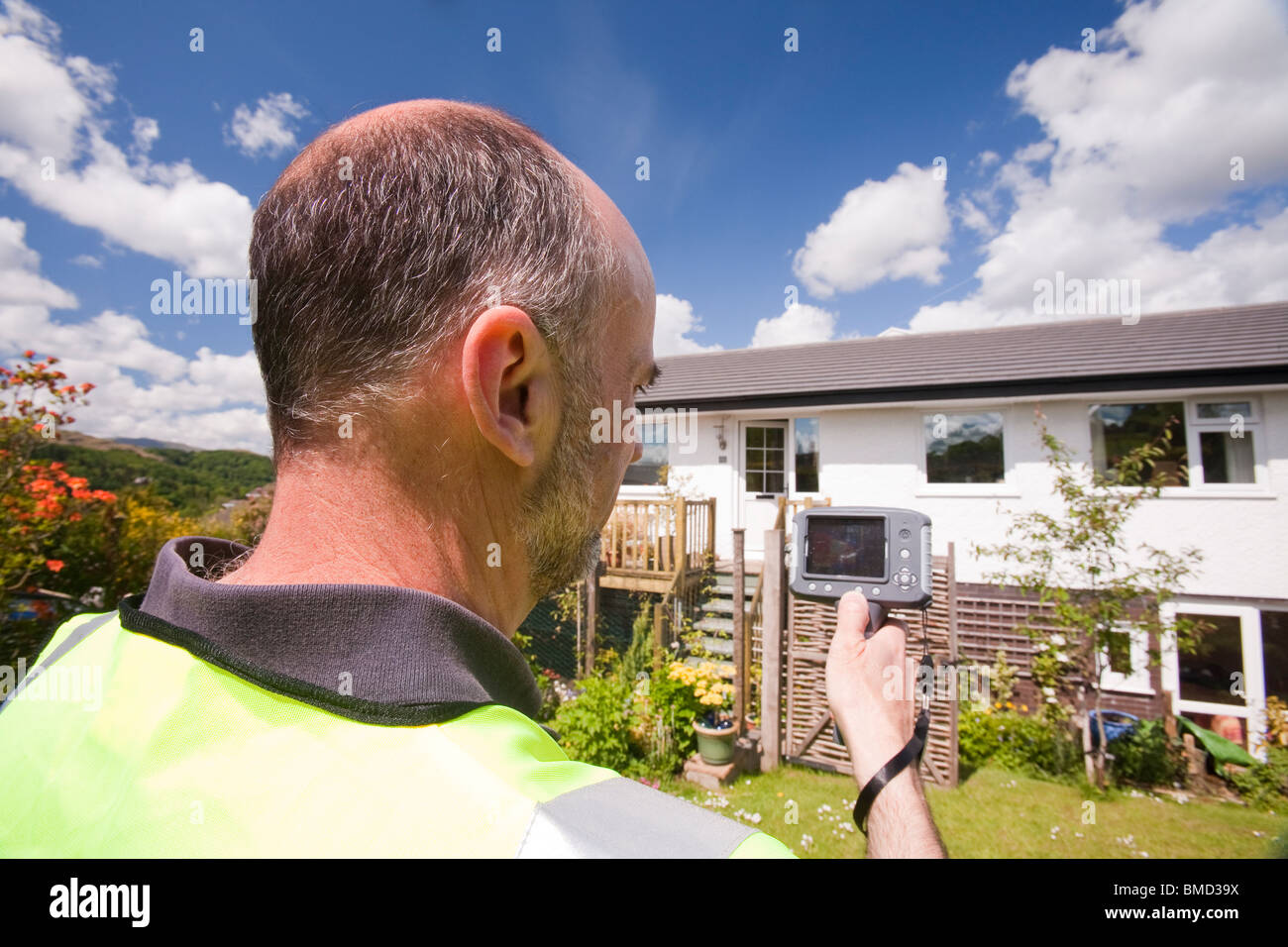 A technician uses a thermal imaging camera to check heat loss from a house Stock Photo Alamy