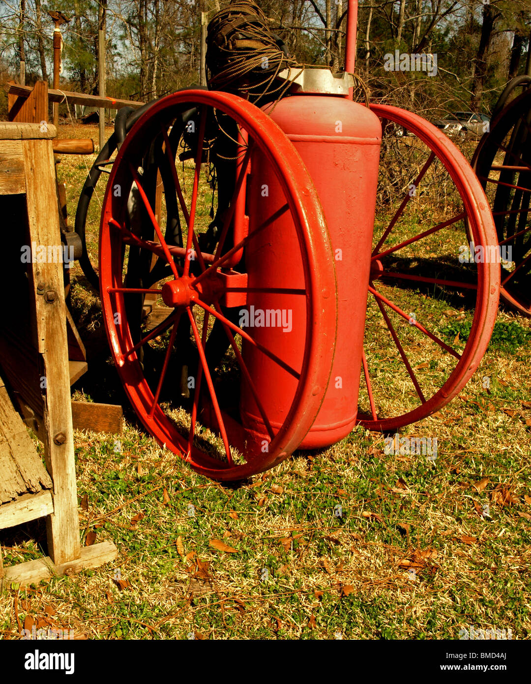 propane gas air compressor tank old red on large wheels sitting in a field Stock Photo