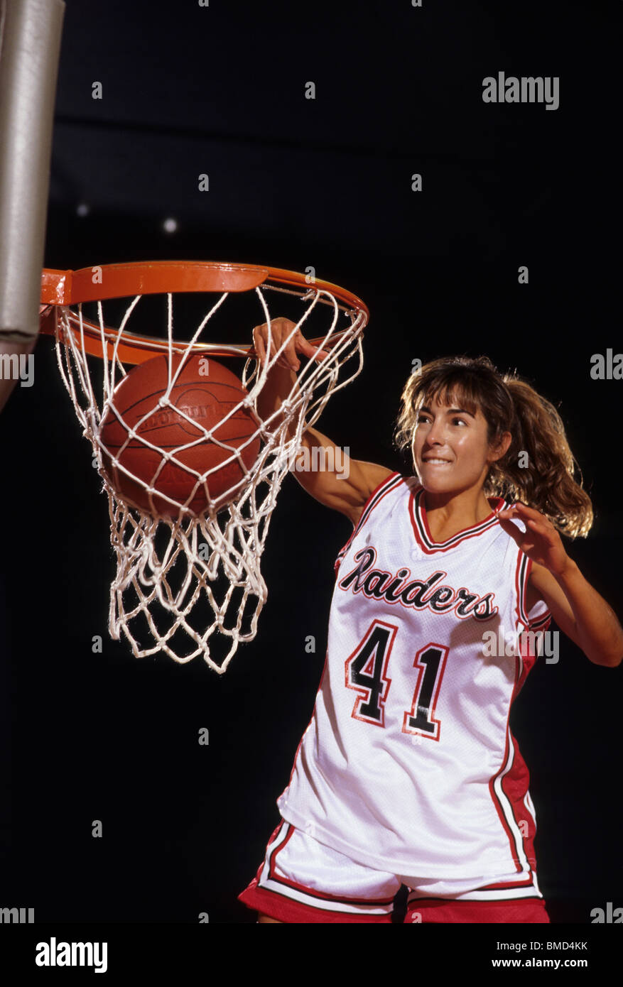 Female basketball player dunking a ball through the hoop Stock Photo - Alamy