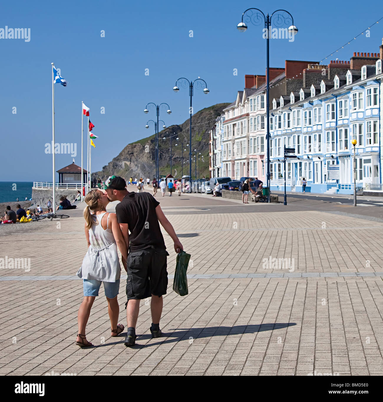 Couple kissing while walking on sea front promenade Aberystwyth Wales UK Stock Photo