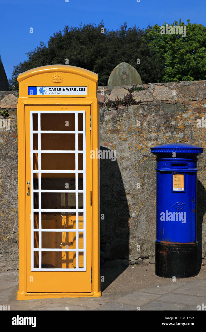 Yellow telephone box and blue letter box on High Street, St. Anne, Alderney, Channel Island, United Kingdom Stock Photo