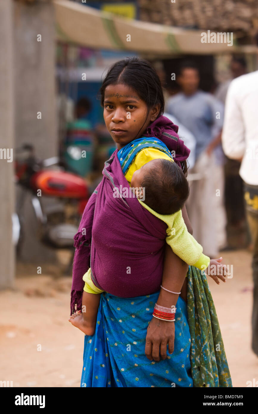 Closeup Young mother wearing saree carrying infant in sling walking through  village market looking serious making eye contact Kanha rural India Stock  Photo - Alamy