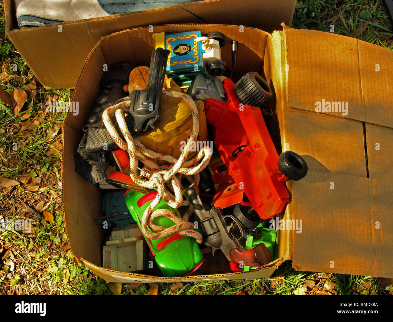 yard sale auction box of old toys including race car guns cardboard