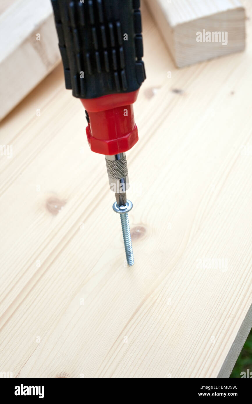 carpentry screwdriver, screw and wood planks. vertical shot. small GRIP Stock Photo Alamy
