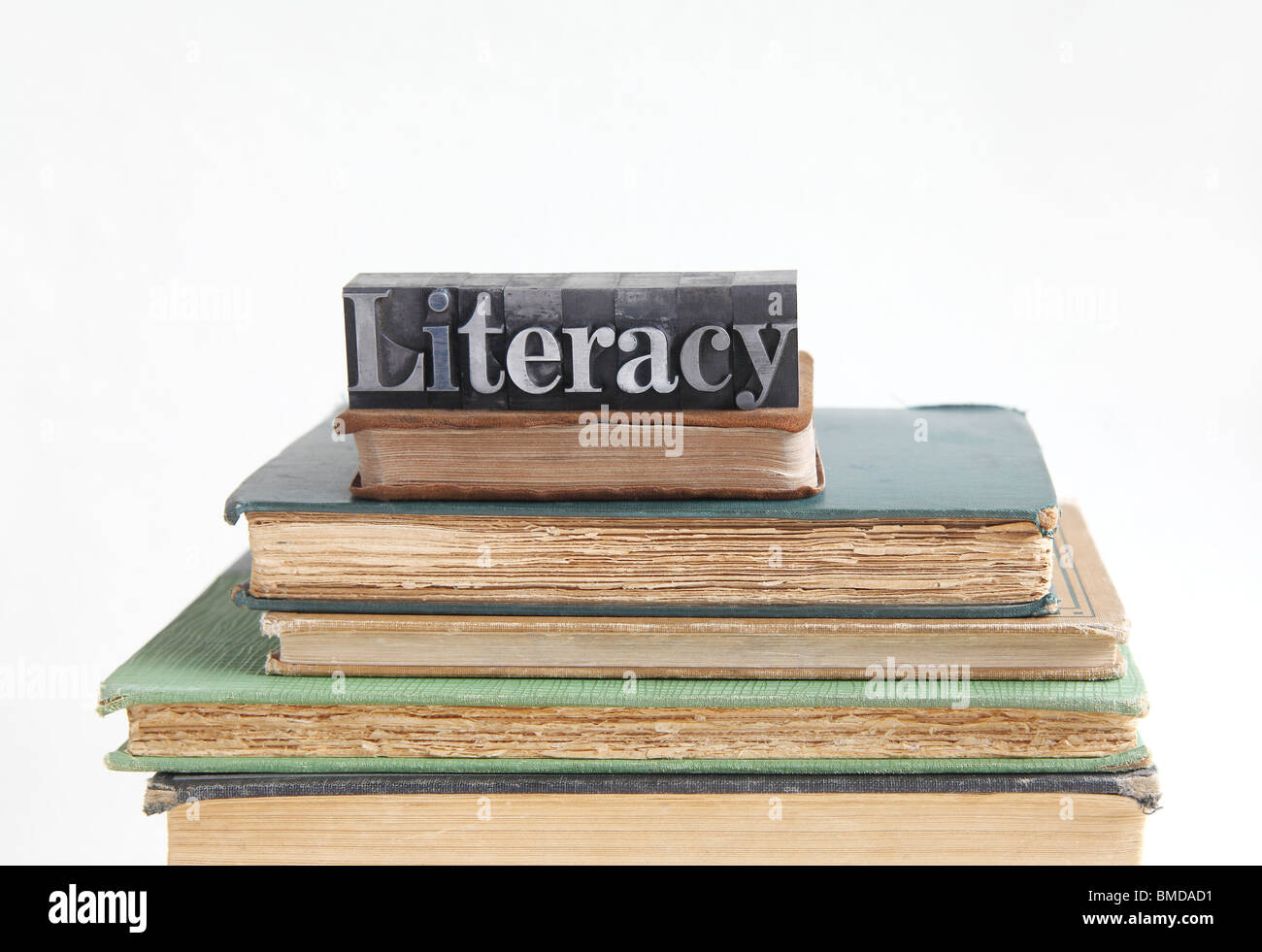 the word literacy on top of several old books Stock Photo