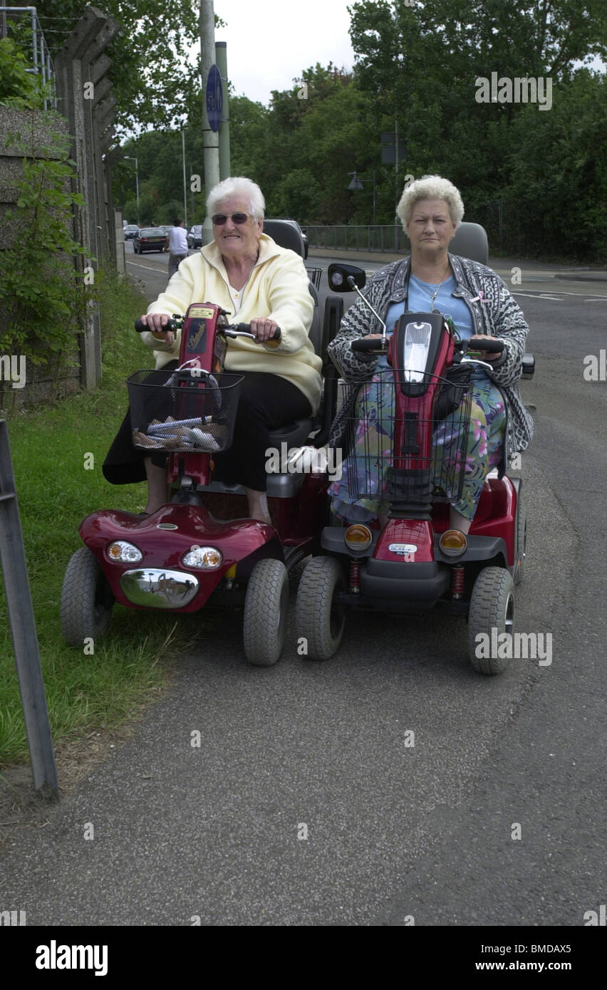 Two female Senior Citizens with their mobility scooters Stock Photo