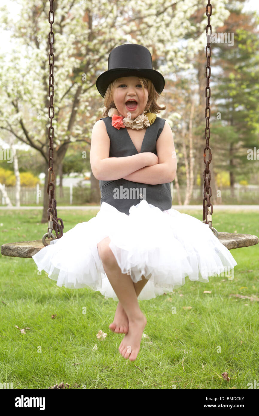 Little girl in top hat on swing Stock Photo