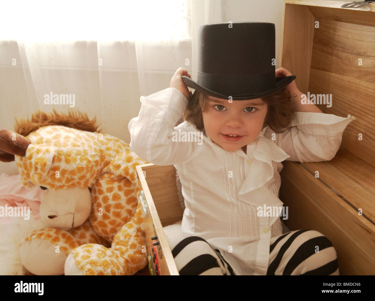 Toddler boy in a dressup box playing Stock Photo