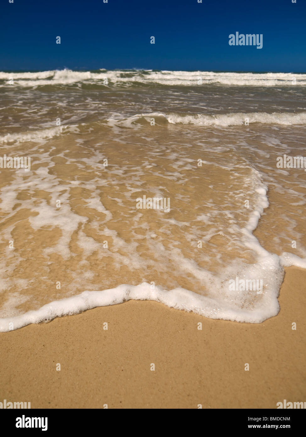 A small wave is coming to the beach sand. Stock Photo
