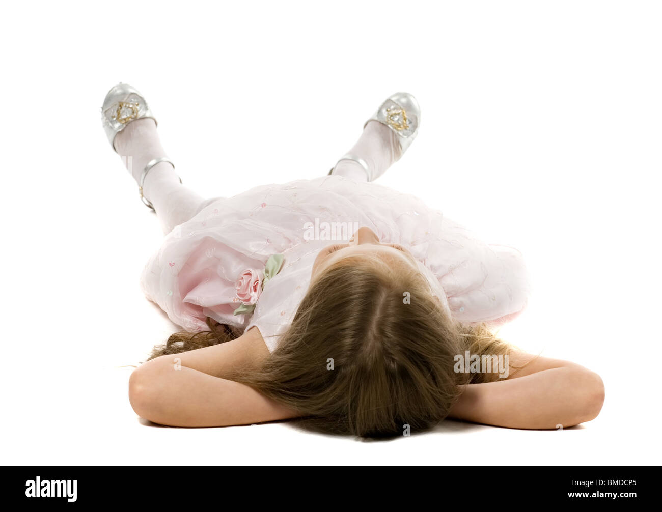 little girl in a beautiful dress lies on a back on a floor, isolated on ...