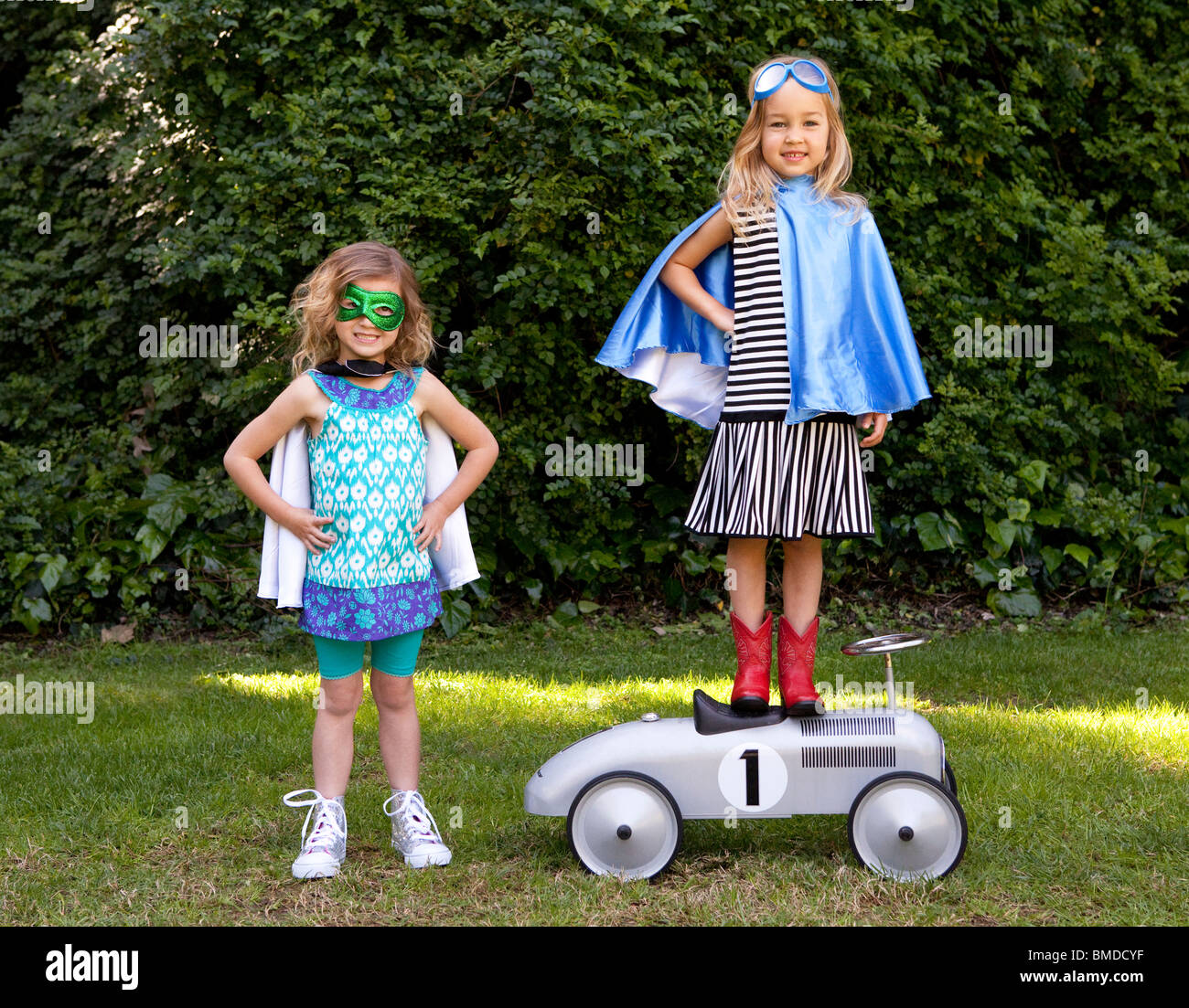 Young girls in capes playing dress up Stock Photo