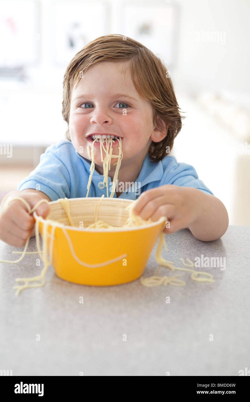 Young boy eating noodles Stock Photo