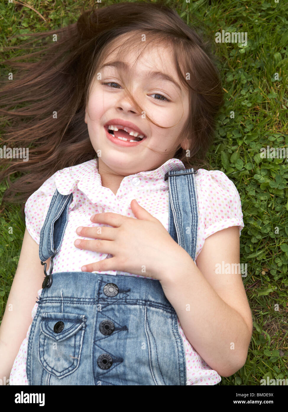 Young girl laying in grass Stock Photo