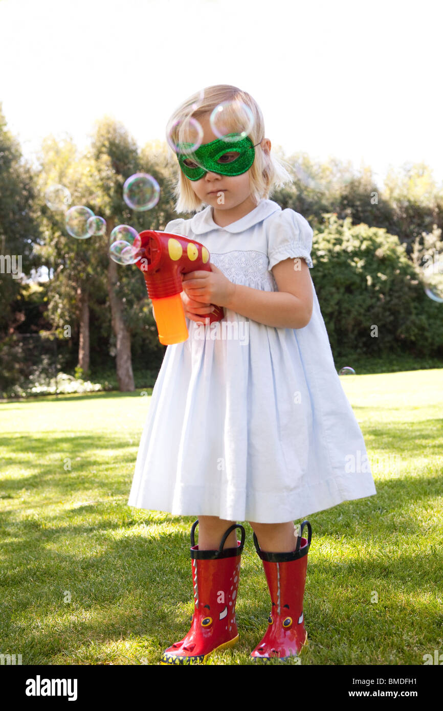 Young girl in mask with bubble gun Stock Photo