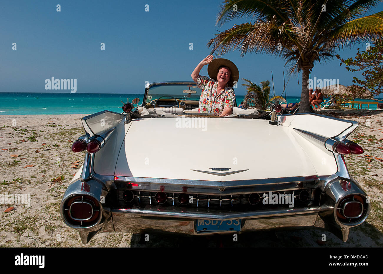 Woman Tourist happy in Classic 1959 White Cadillac Auto on beautiful beach of Varadero Cuba Stock Photo