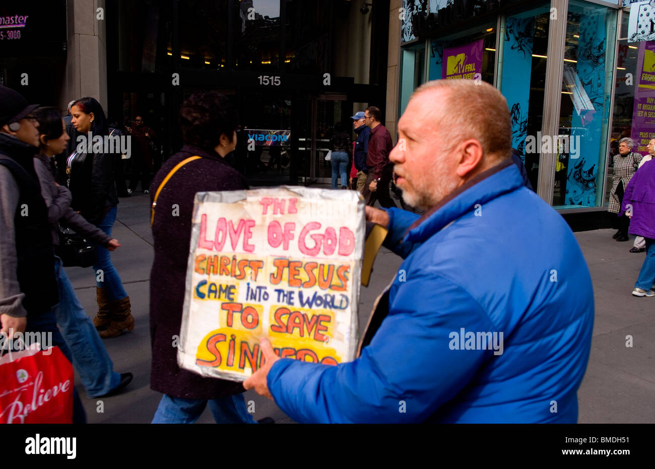 Man holding religious sign to people passing by about Jesus in Times Square in New York City New York Stock Photo