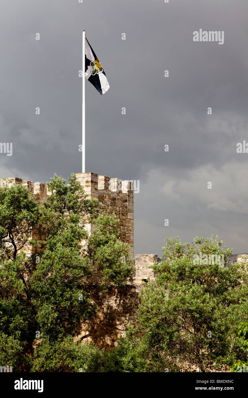 A flag flying on the battlements of Sao Jorge Castle in Lisbon, Portugal, against a stormy sky. Stock Photo