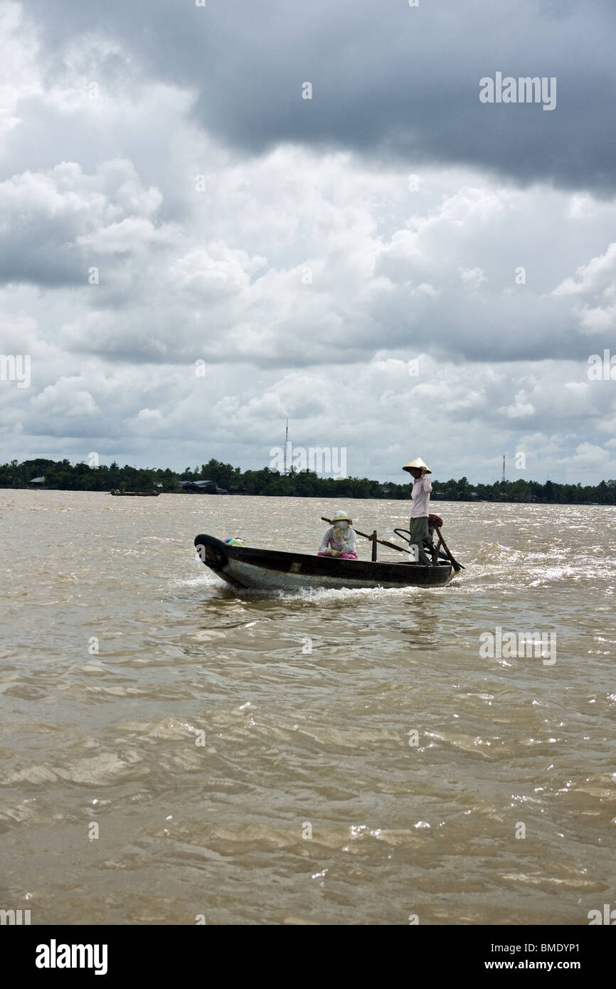 Woman driving boat along Mekong Delta, Vietnam Stock Photo