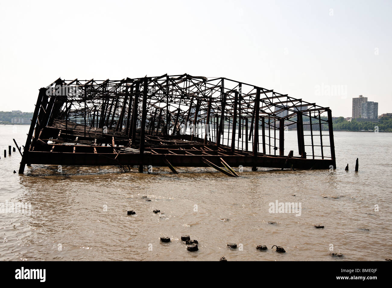 twisted steel skeleton of burned out Hudson River railroad pier formerly used to offload cargo from boat to train on West side Stock Photo