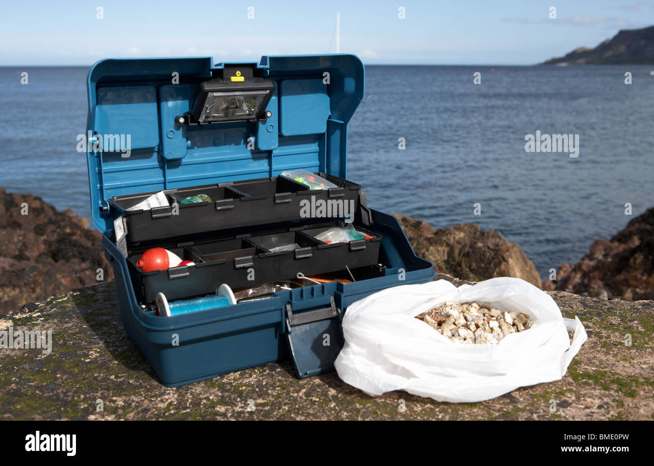 fishing tackle box filled with sea fishing gear and bag of ragworm bait on  the county antrim coast northern ireland uk Stock Photo - Alamy