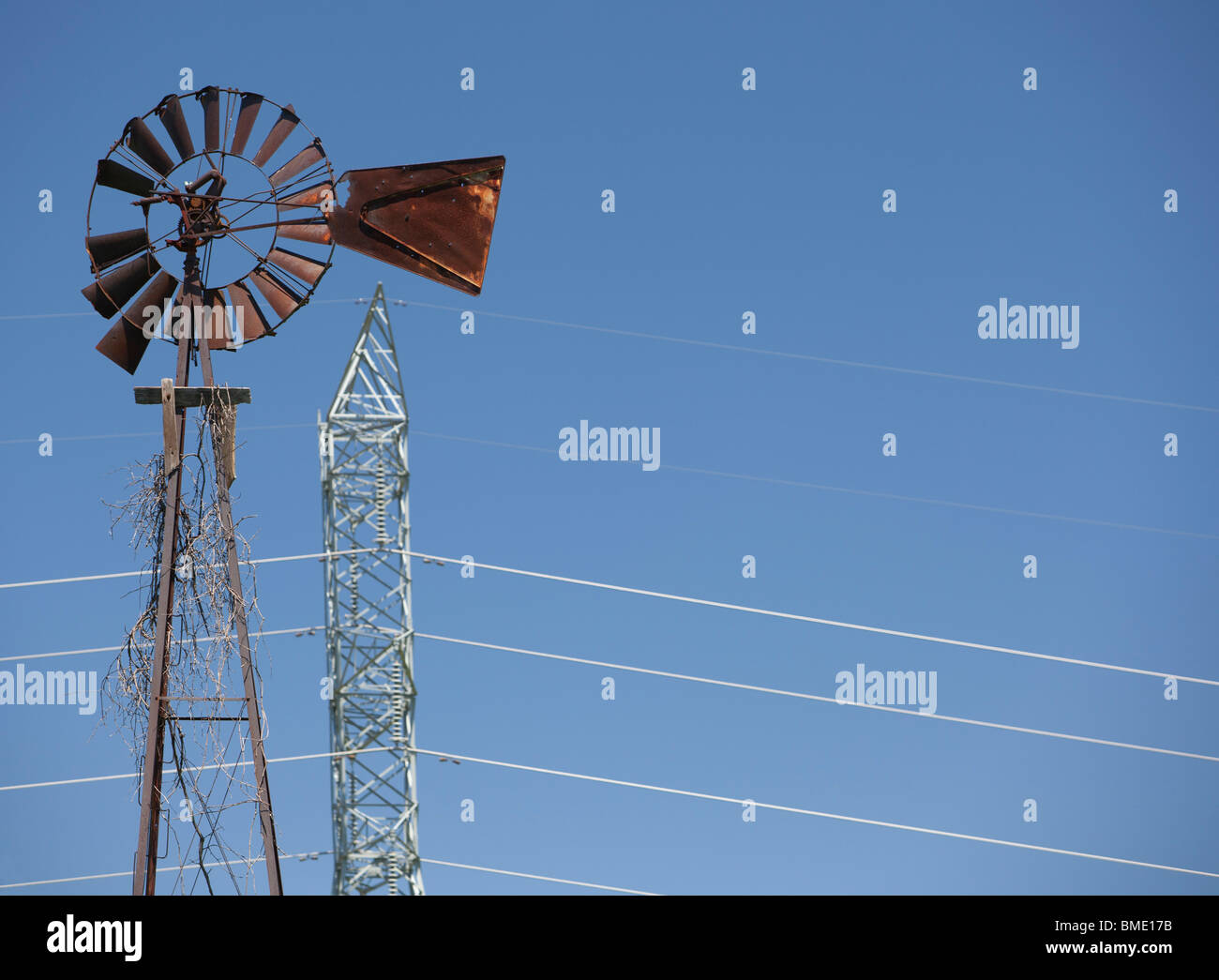 Antique Windmill and Modern Power Line Stock Photo