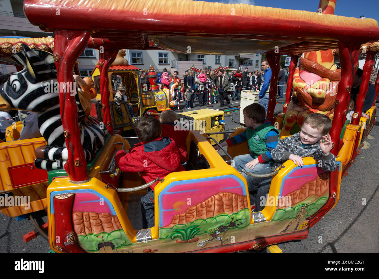 young children on a train ride at an outdoor funfair event on mayday in holywood county down northern ireland uk Stock Photo