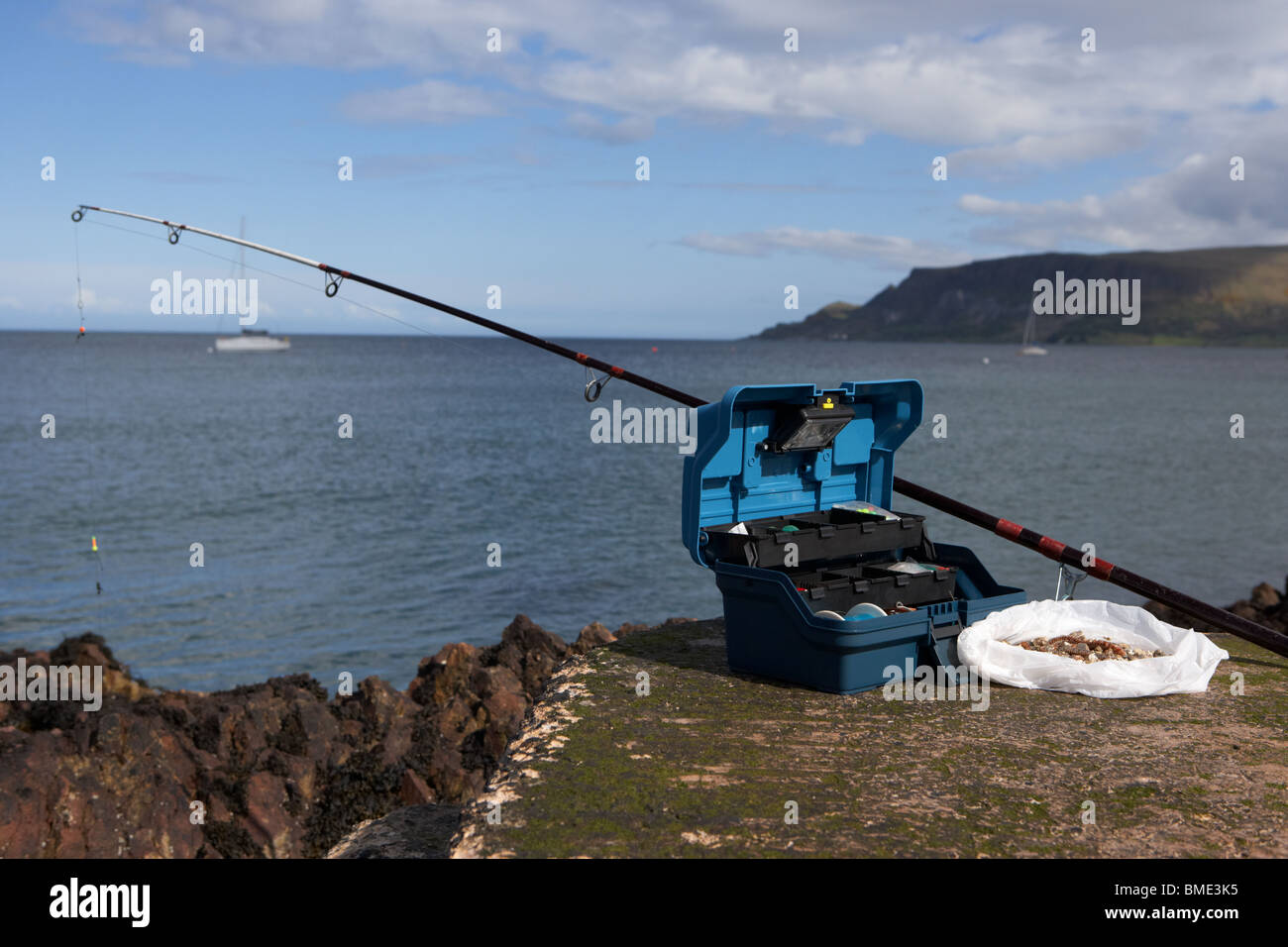 fishing tackle box filled with sea fishing gear rod and bait on the county antrim coast northern ireland uk Stock Photo