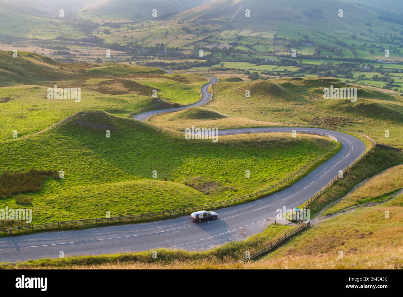 Car driving down the winding road to Edale from Mam tor Derbyshire Peak District National Park England UK GB EU Europe Stock Photo