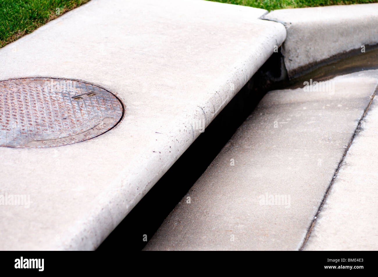 A manhole cover and gutter in the street. Wichita, Kansas, USA. Stock Photo