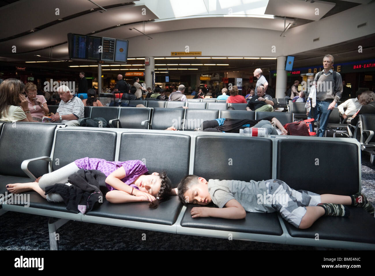 Children asleep in departures due to flight delay delayed Terminal 3, Heathrow airport, London UK Stock Photo