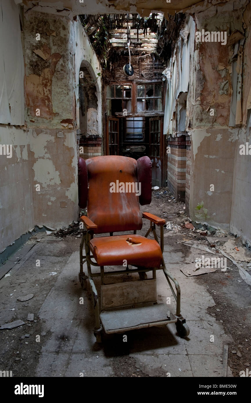 Dilapidated Hospital Chair in a Derelict Psychiatric Asylum Stock Photo