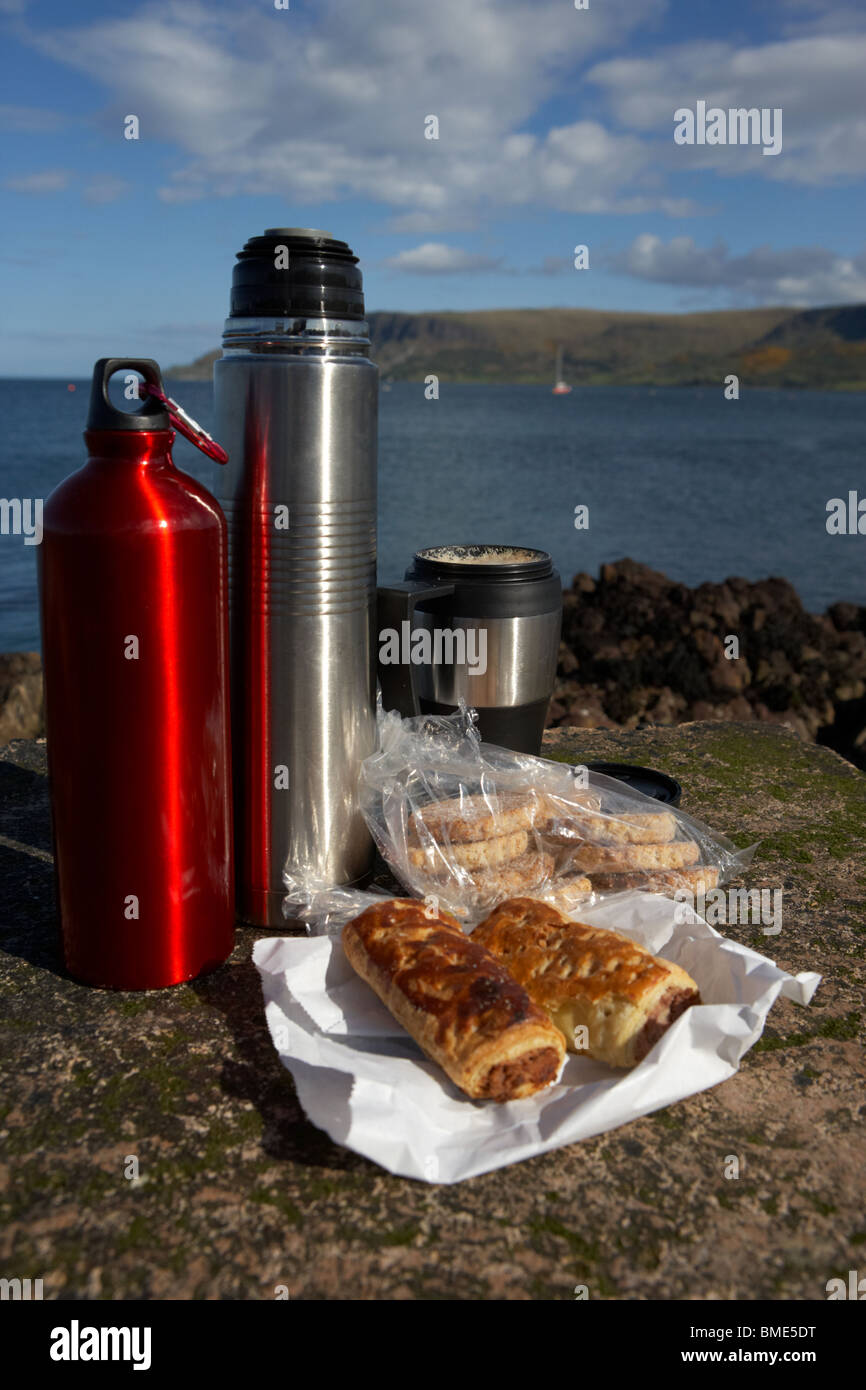 lunch including sausage rolls biscuits flasks and coffee on rocks on the county antrim coast northern ireland Stock Photo
