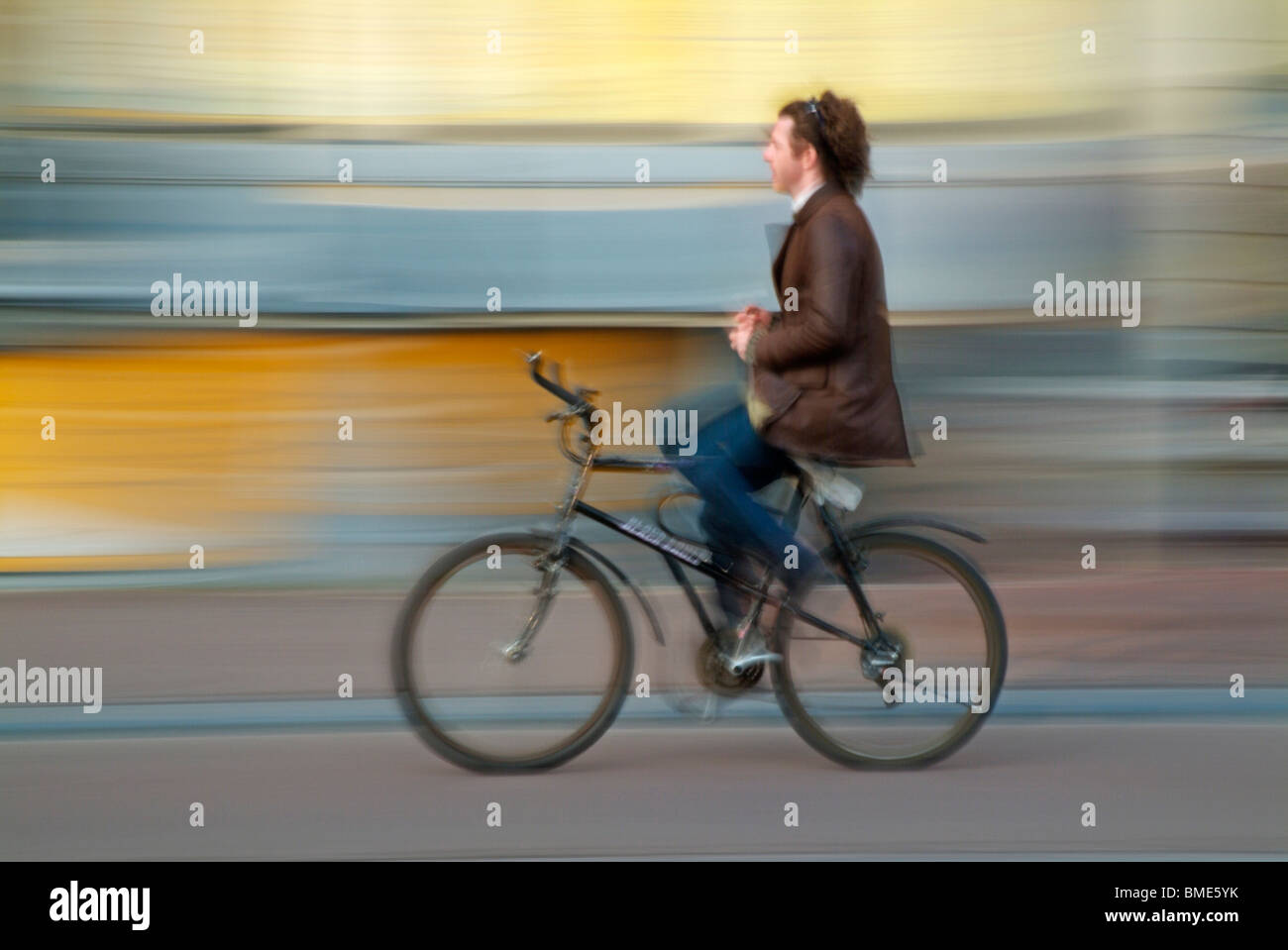 Man cycling to work with hands off the handlebars on a bicycle in central Amsterdam Holland Netherlands EU Europe Stock Photo