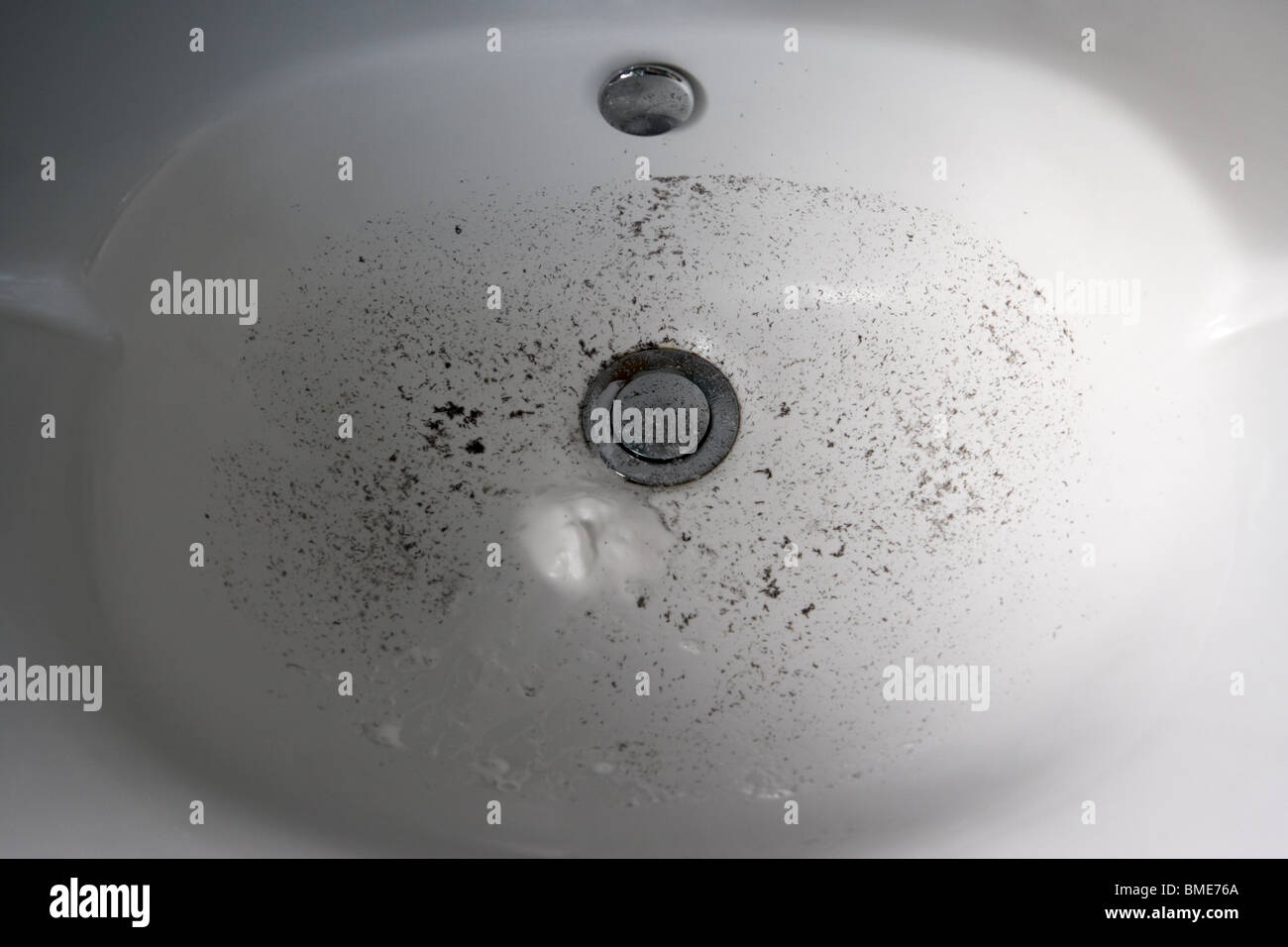 dirty bathroom sink with remnants of mans shaving Stock Photo