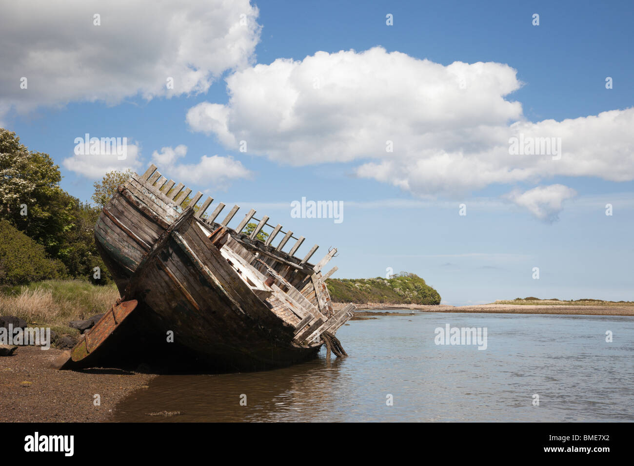 Old wooden hull of a ship wreck on seashore in bay's tidal lagoon at Traeth Dulas, Isle of Anglesey (Ynys Mon), North Wales, UK Stock Photo