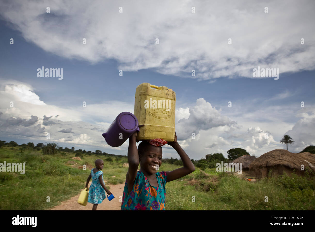 Child carrying water in a village - Amuria District, Uganda. Stock Photo
