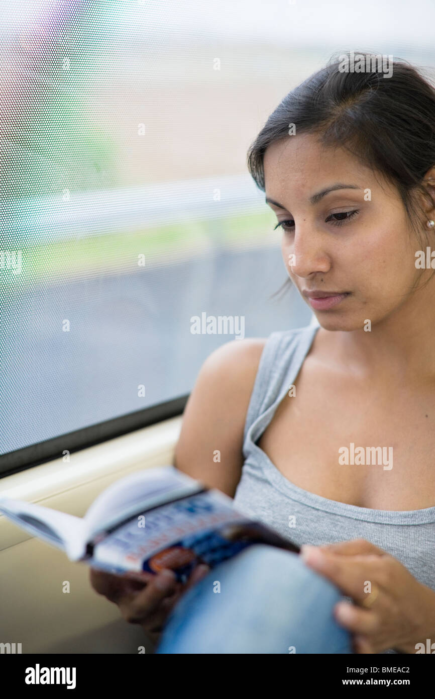 Woman reading a book at the bus Stock Photo