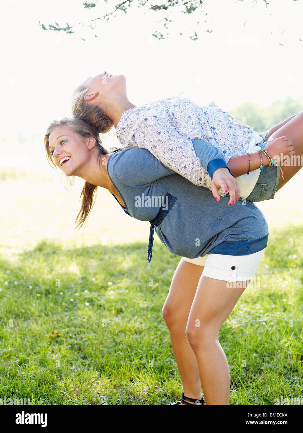 Young woman lifting friend on her back Stock Photo