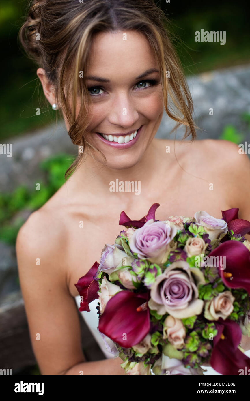 Bride holding bouquet, looking at camera Stock Photo