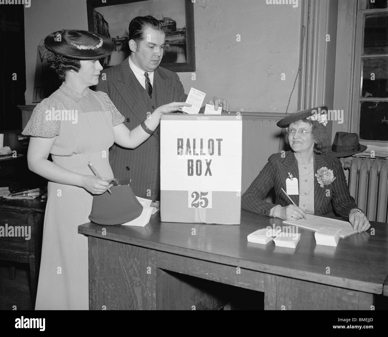 Vintage 1930s photo of a man and woman placing their votes in a ballot box in Washington DC as an election official looks on. Stock Photo