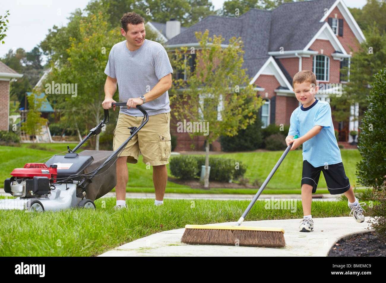 A Father And Son Working In The Yard Stock Photo