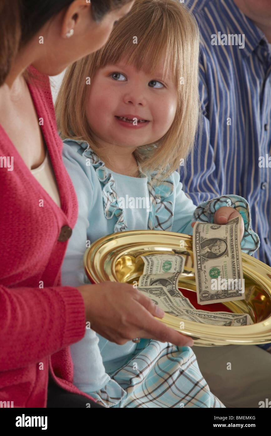 A Mother Passing The Collection Plate To Her Daughter Stock Photo