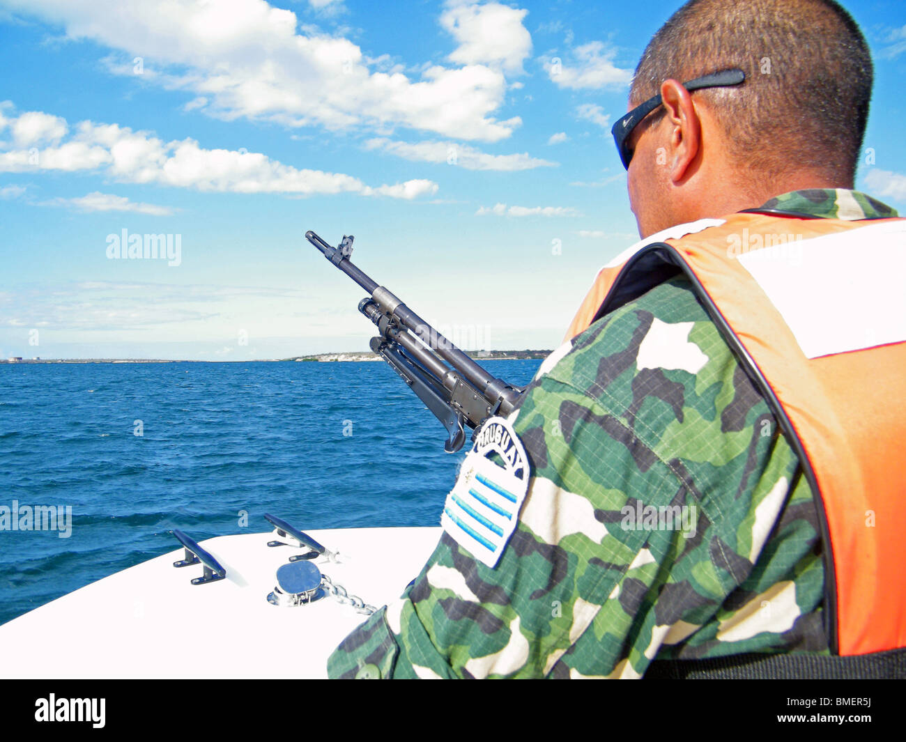 A United Nations peacekeeper mans a mounted gun at the bow of a patrol boat searching for drug traffickers, Fort Libertè, Haiti Stock Photo