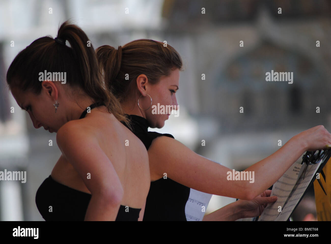 Women prepare to play a song at a cafe in St Mark's Square, Venice, Italy Stock Photo