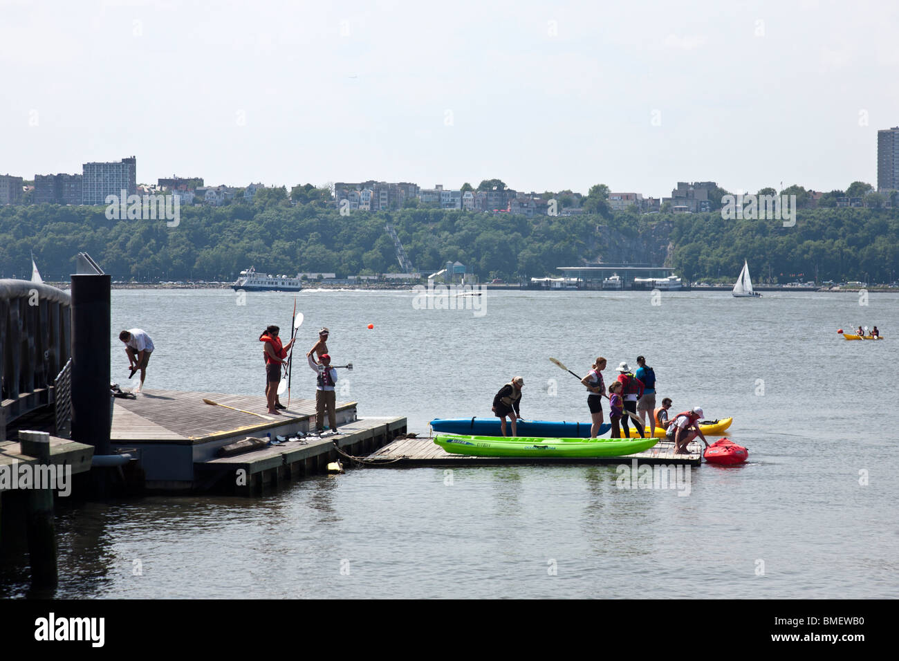 people launching colorful kayaks from floating launch platform on
