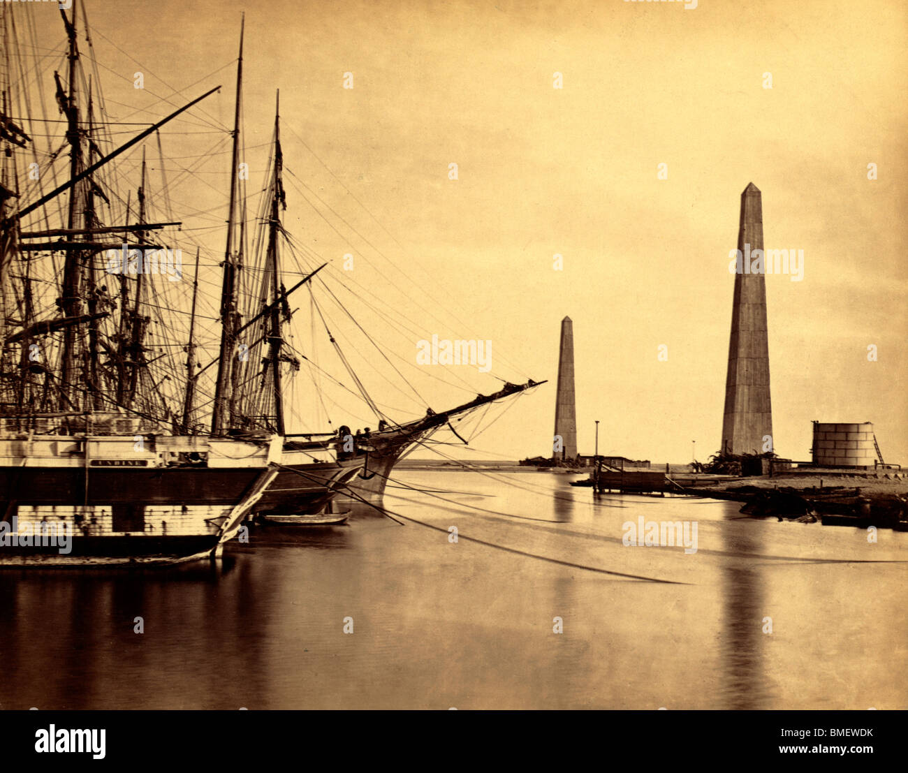 Suez canal entrance at Port Said - Obelisks on shore and ships moored at Port Said, the entrance to the Suez Canal. circa 1860 Stock Photo