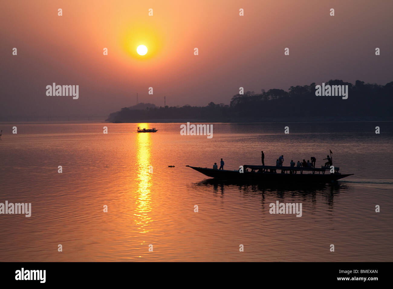 Sunset on Brahmaputra River with Passing Passenger Boat, Guwahati, Assam State, India Stock Photo