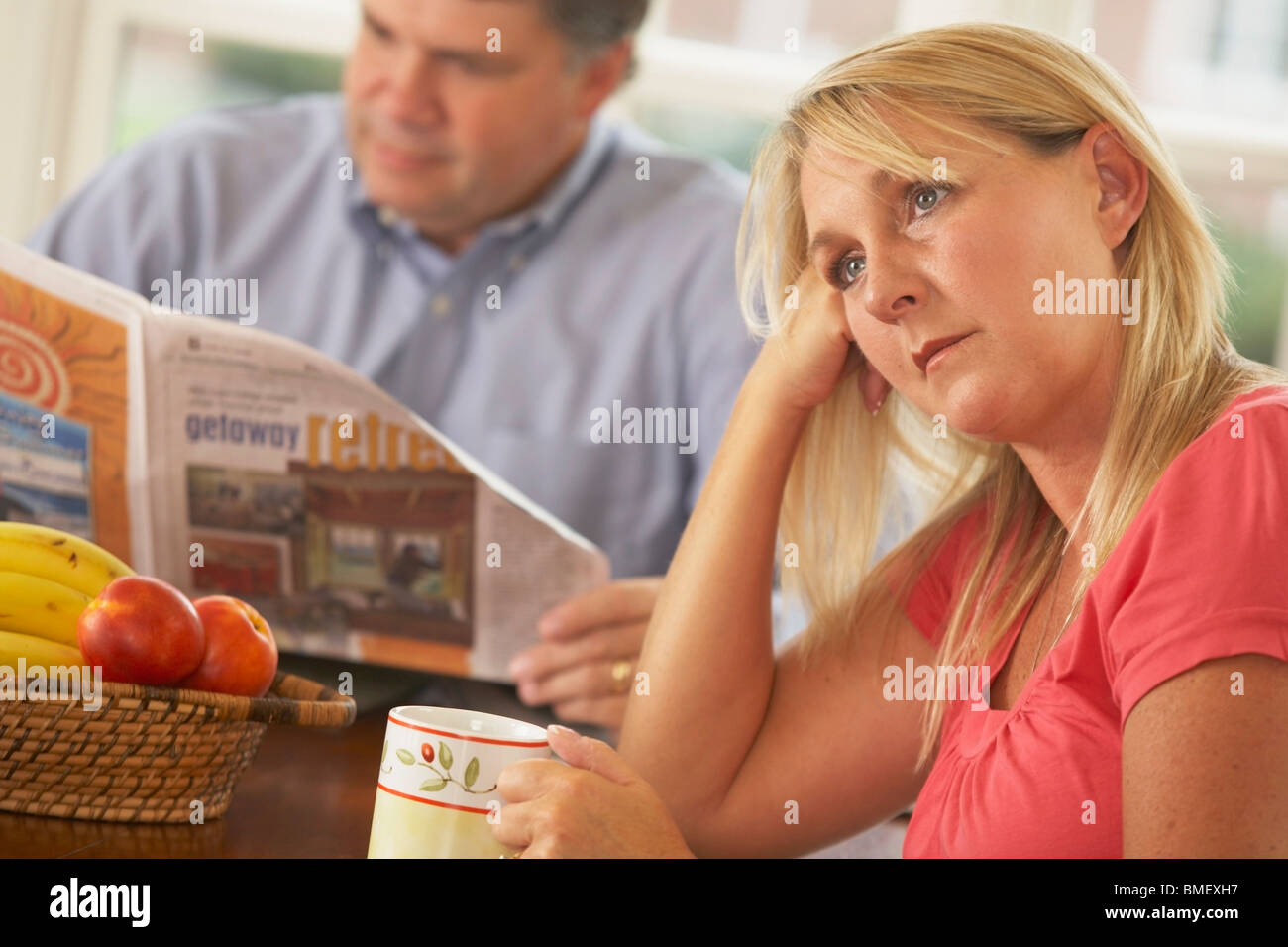 A Wife Being Ignored By A Husband Reading The Newspaper Stock Photo
