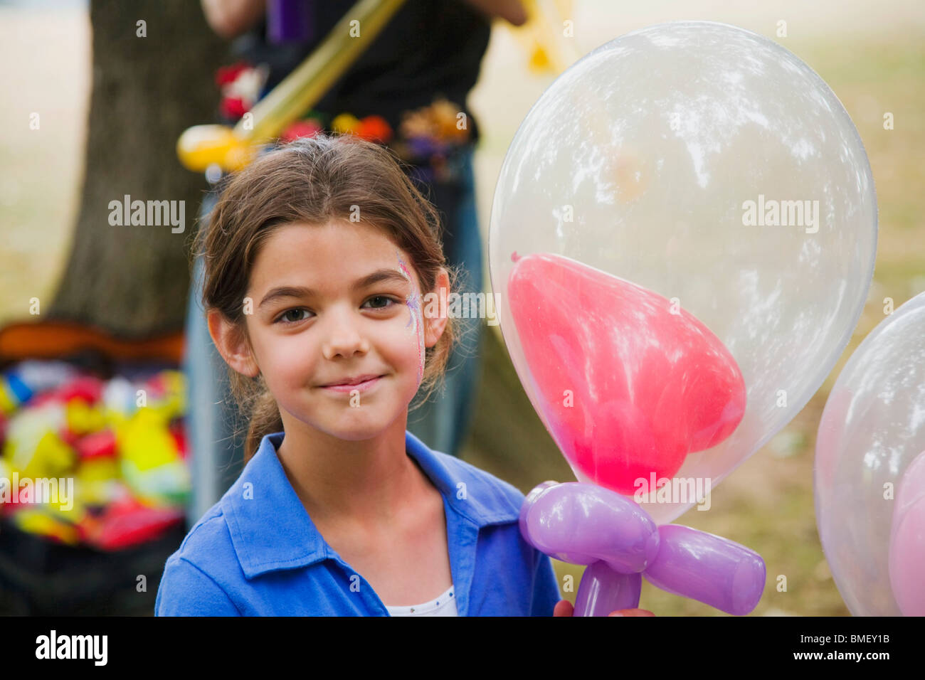 A Young Girl Holding A Balloon With A Heart Balloon Inside It Stock ...